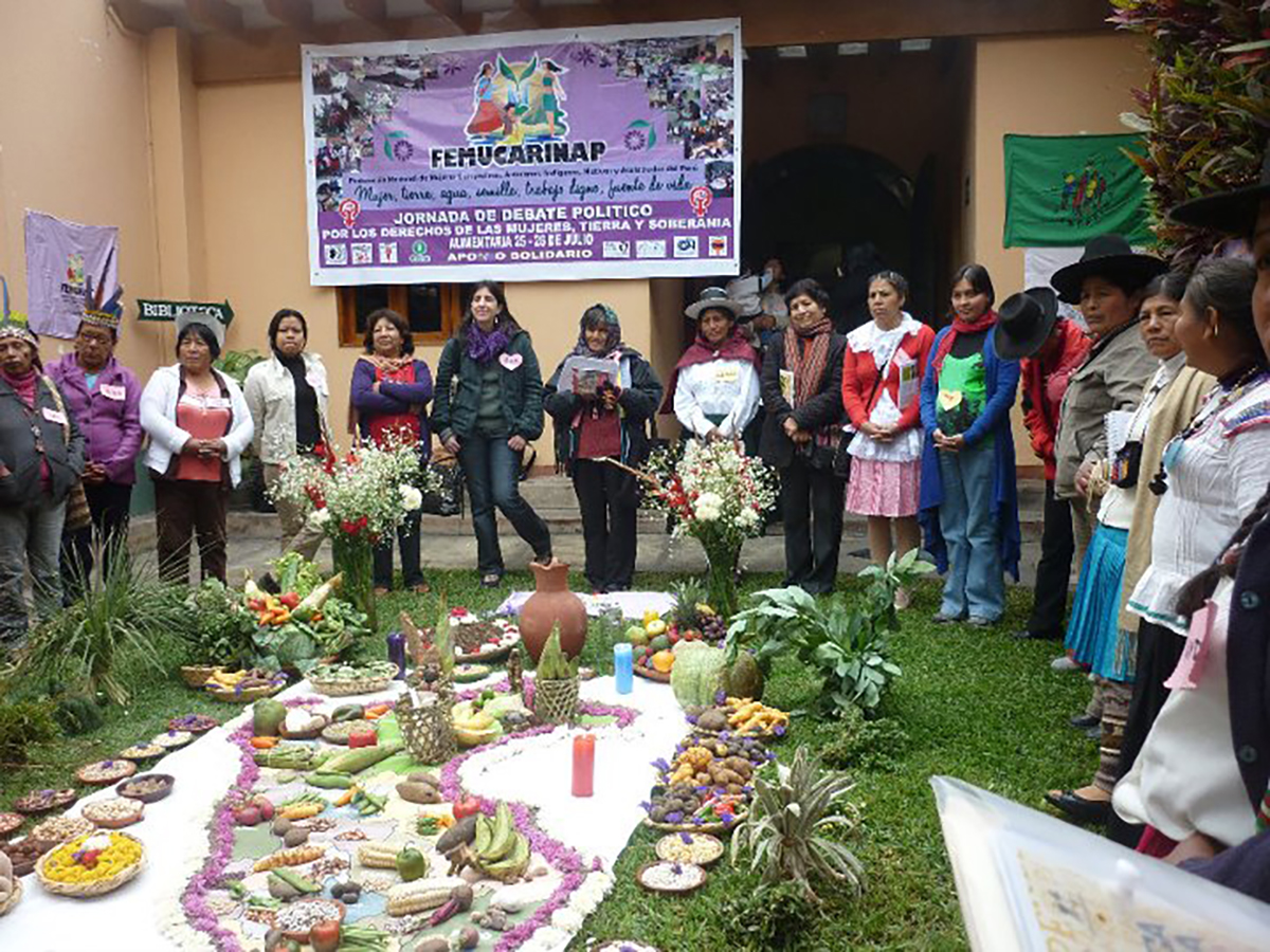 grupo de mujeres bajo una pancarta morada